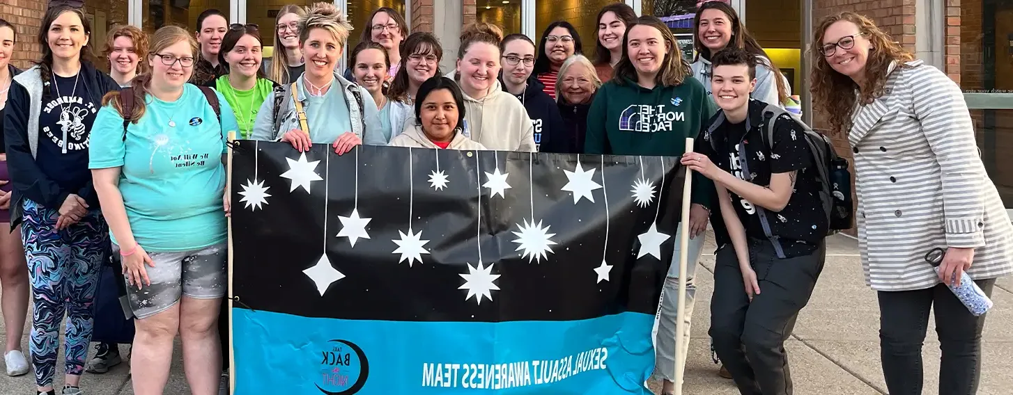 A group of students posing with a Take Back the Night banner